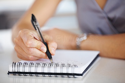 Woman\'s hand holding a pen taking notes