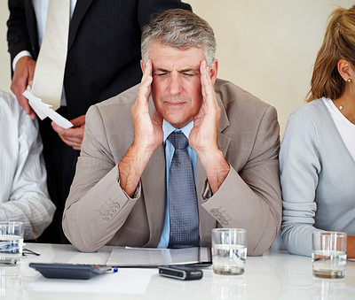 Elderly businessman having headache at meeting