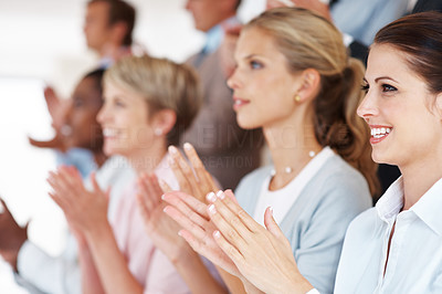 Happy business team applauding at a seminar