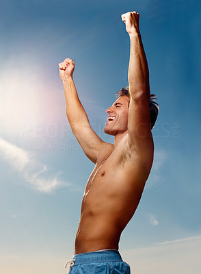 Excited young guy with his hands raised towards the sky