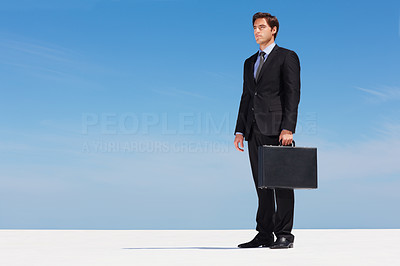 Thoughtful young business man holding a briefcase