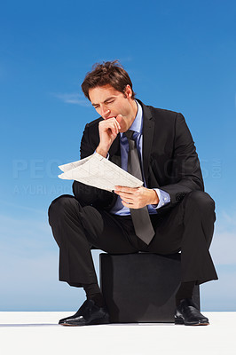 Bored business man reading financial newspaper
