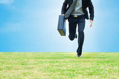 Business man running with a briefcase on a field
