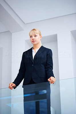 Business woman standing by glass wall