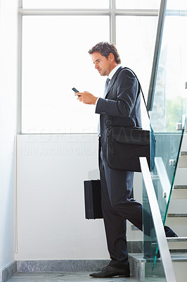 Business man using cellphone on stairs