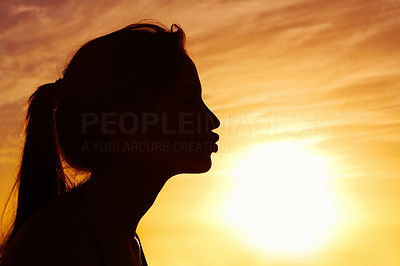 Closeup of a woman kissing the sun against beautiful sky