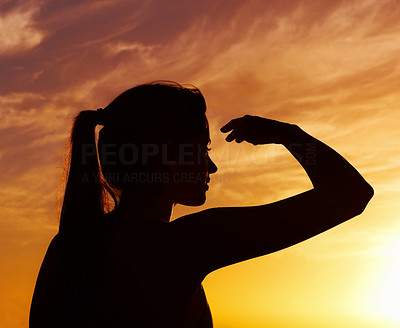 Silhouetted woman looking at something interesting at sunset