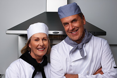 Smiling male and female chefs together standing in the kitchen