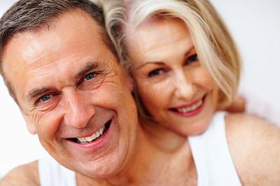 Cheerful mature man with wife embracing from back