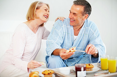 Couple with a mature man applying jam on bread