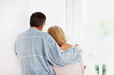 Romantic mature couple looking through glass window