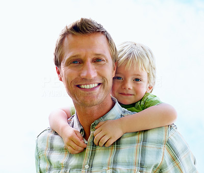 Happy mature man carrying his son on back against white
