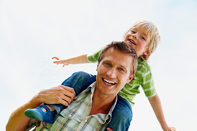 Cheerful father carrying his son on shoulder against white