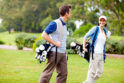 Couple carrying golf bags