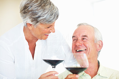 Cheerful couple toasting with red wine