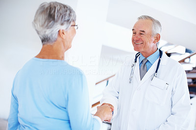 Mature doctor and woman shaking hands