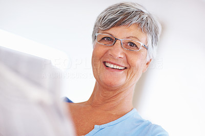 Smiling woman reading newspaper