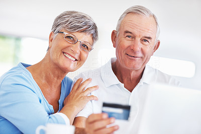 Smiling mature couple shopping online