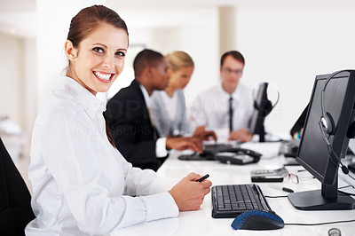 Businesswoman smiling with her team working in background