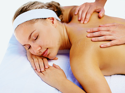 Serene woman receiving a shoulders massage at day spa on white