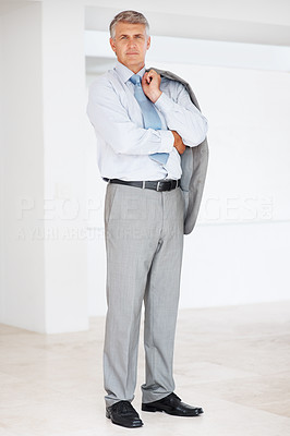 Mature businessman holding coat over shoulders