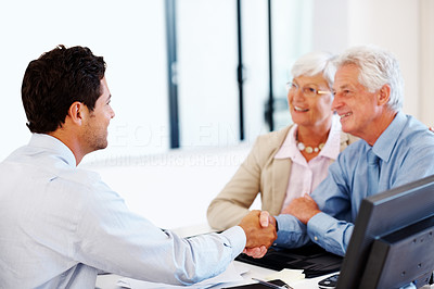 Happy old couple shaking hands with agent