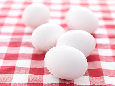 Farm fresh white eggs on picnic tablecloth