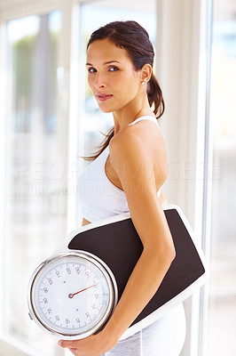An attractive young woman holding weight scale