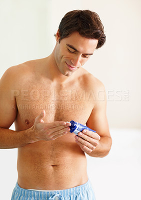 Handsome man squeezing out shaving cream to his fingers
