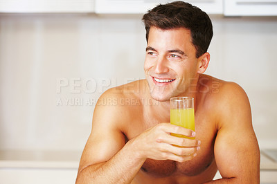Muscular man with a glass of juice looking away - copyspace
