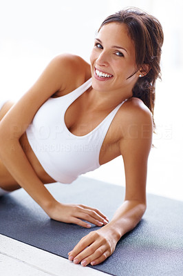 Smiling young woman lying on yoga mat