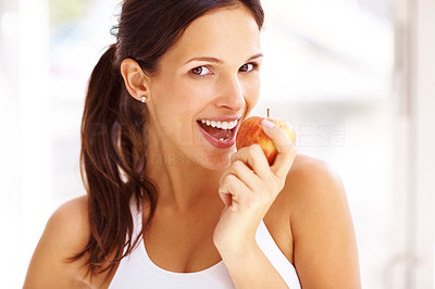 Portrait of fit young girl biting a fresh ripe apple