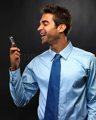 Young business man reading text message and laughing