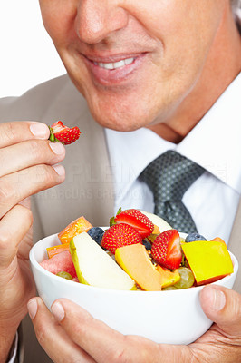 Business man eating strawberry