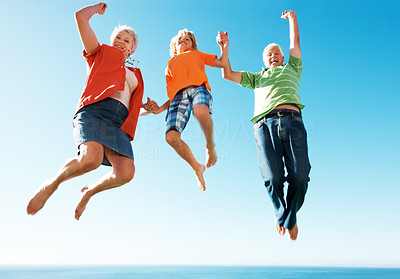 Excited old couple jumping in air with little boy