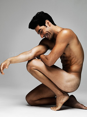 Happy young nude man smiling over a thought isolated on gray