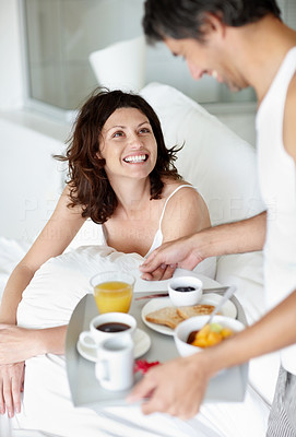 Portrait of man serving woman breakfast in bed