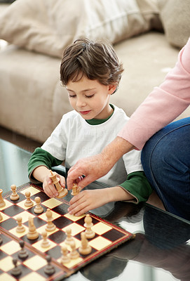 Cute little boy and his grandmother playing chess