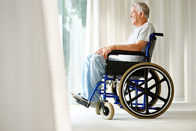 Disabled old man on wheelchair looking outside