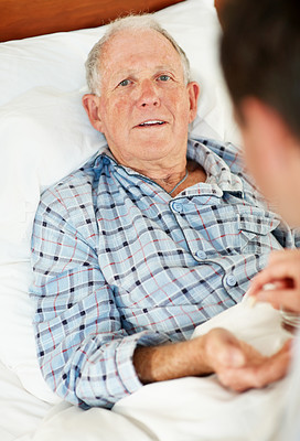 Elderly man receiving pill from the doctor