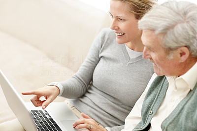Happy lady showing something interesting on laptop to her father