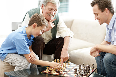 Happy family playing a game of chess together