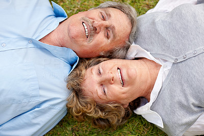 Portrait of lovely old couple lying on grass