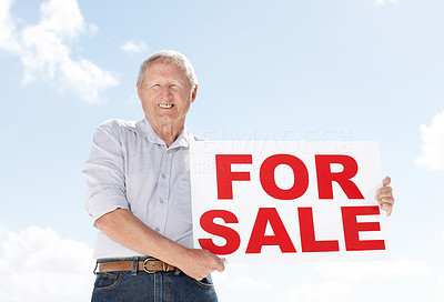 A retired senior man holding sale sign - Outdoor