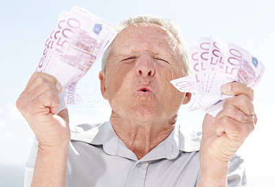 An excited senior man holding money in hand