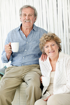 Retired senior couple sitting with cup of coffee