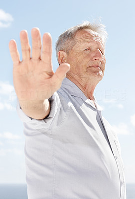 An old man showing stop sign against the sky - Outdoor