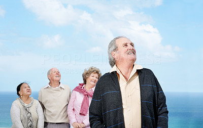 Old man looking away with his friends in background