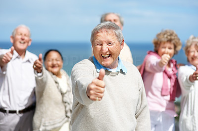 Excited old man showing thumbs up sign with his friends