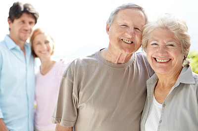 Cute old couple smiling with adult children